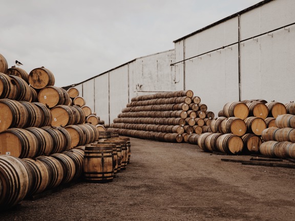Piles of wooden whisky barrels being stored outside