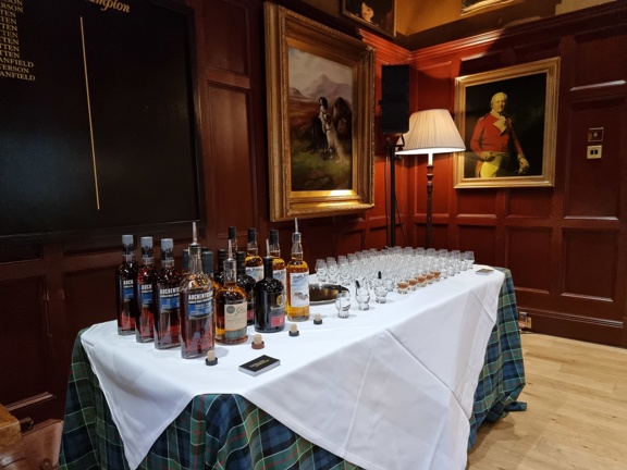 Table laid with white and tartan table cloths, whisky bottles and tasting glasses