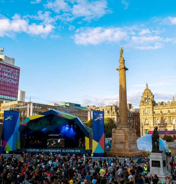Crowd stands in front of stage with European Championships 2018 banner in George Square, Glasgow.