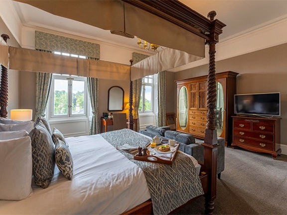 Large hotel bedroom with four poster bed
