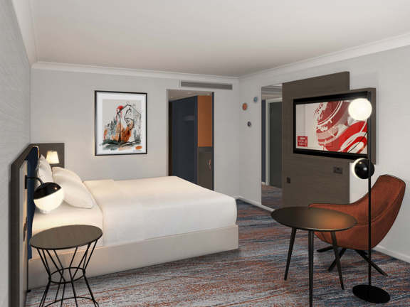 Artists impression of new hotel bedroom - orange and blue carpet, white bed in centre of room, grey walls, leather chair