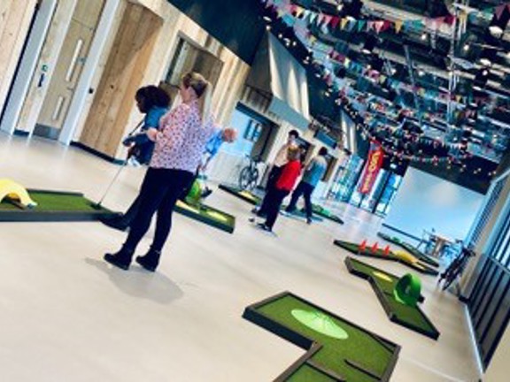 People playing mini golf set up indoors