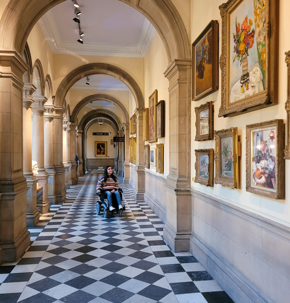Person in wheelchair in the galleries of Kelvingrove Art Gallery and Museum