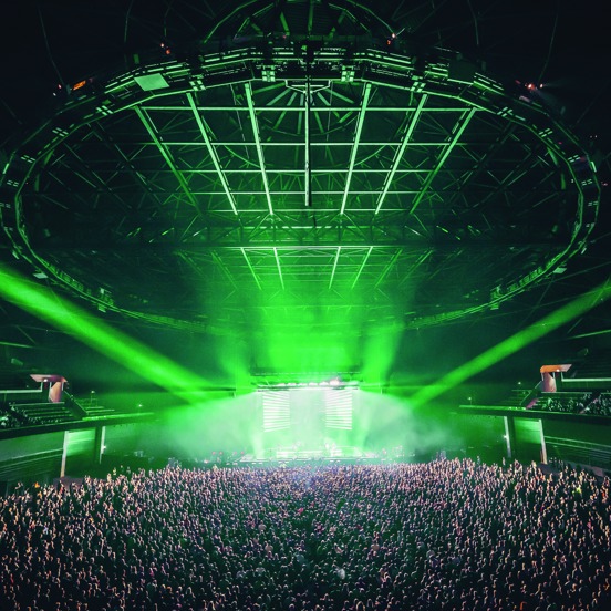 View of OVO Hydro stage during busy concert, illuminated in green light.