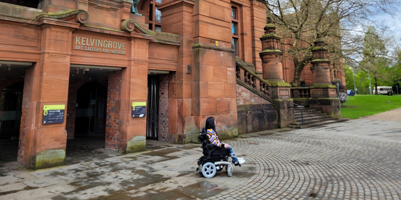 Woman in wheelchair in front of Kelvingrove Art Gallery and Museum